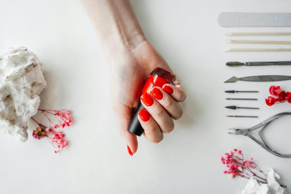 Manicured woman's nails with red nail polish.