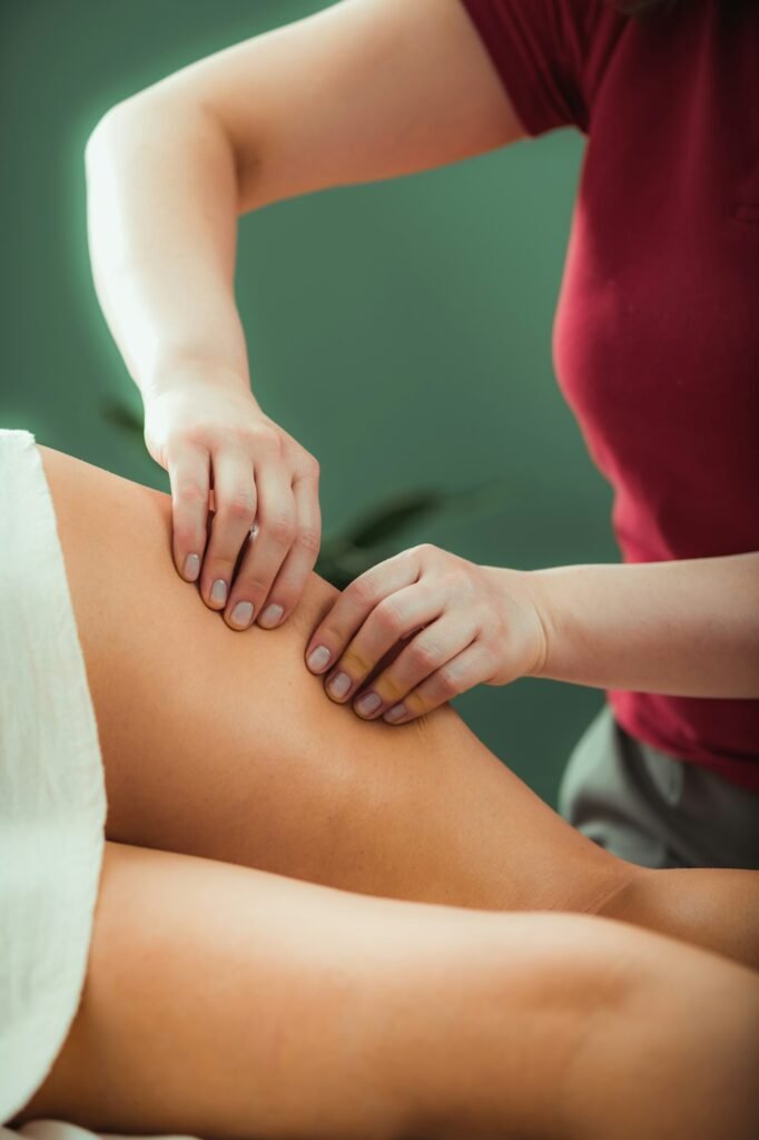 Relaxing legs massage, hands of a female massage therapist massaging female client’s legs